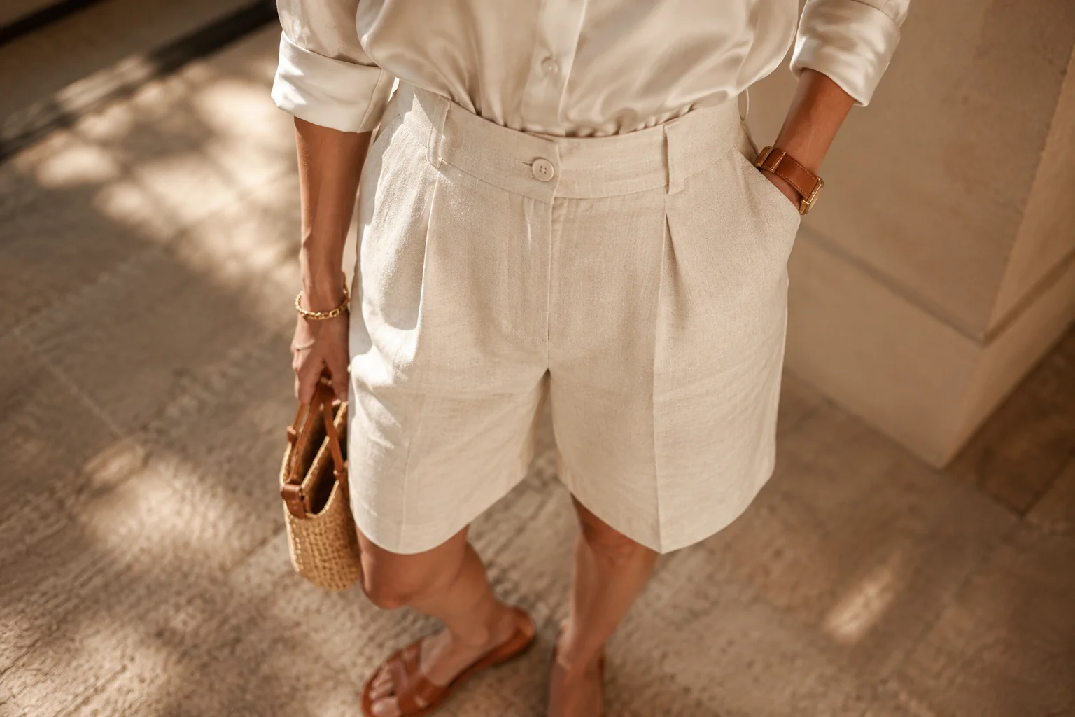 Styling tips to make Bermuda shorts look chic — high-waisted, tucked in top and simple sandals 